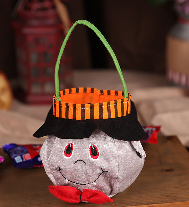 Halloween-themed candy basket with a ghost face design on a wooden surface.