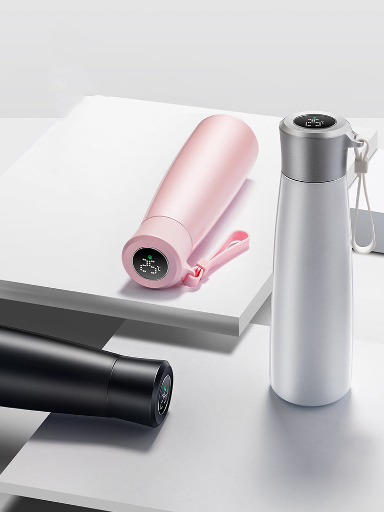 Three water bottles of different colors on a light gray surface