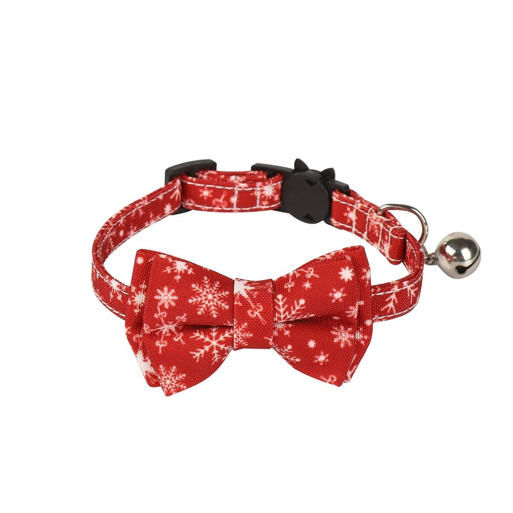 Red and white snowflake patterned dog collar with bow tie and bell on a white background