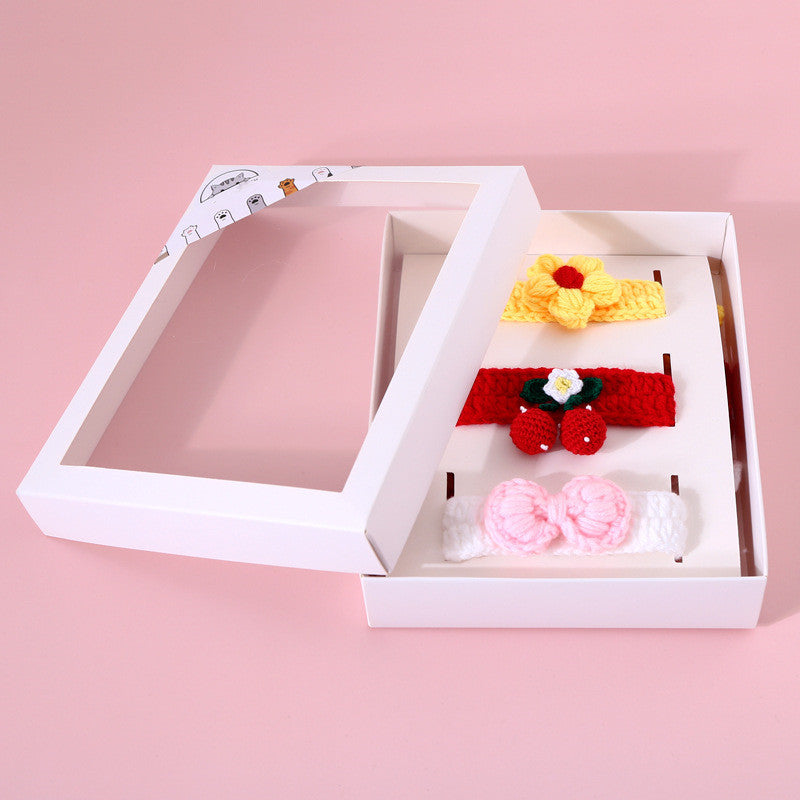 Set of colorful hair accessories in a white box on a pink background