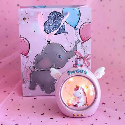 Decorative lamp with a cartoon character and a card with balloons on a pink background