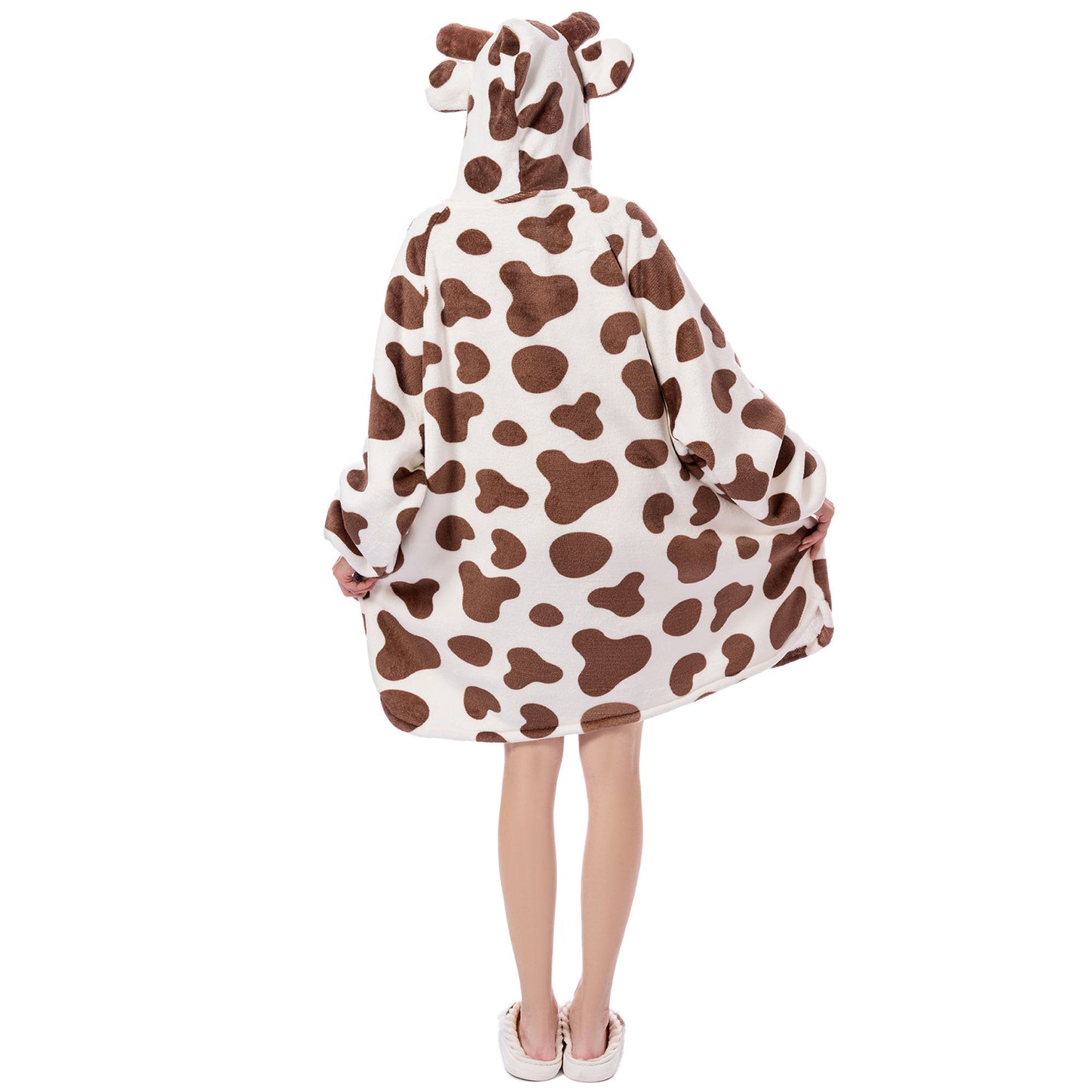 Person wearing a cow-patterned poncho on a white background