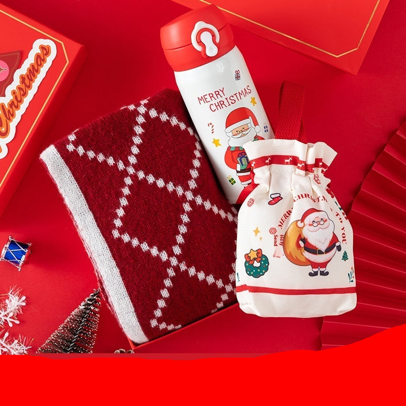 Christmas-themed scarf, candy bag, and thermos cup on a red background