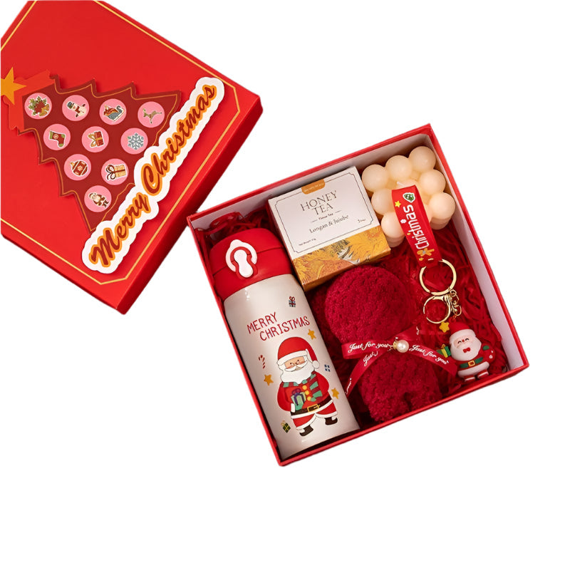 Christmas-themed gift set with thermos cup, towel, tea, candle, and keychain in a decorative box.