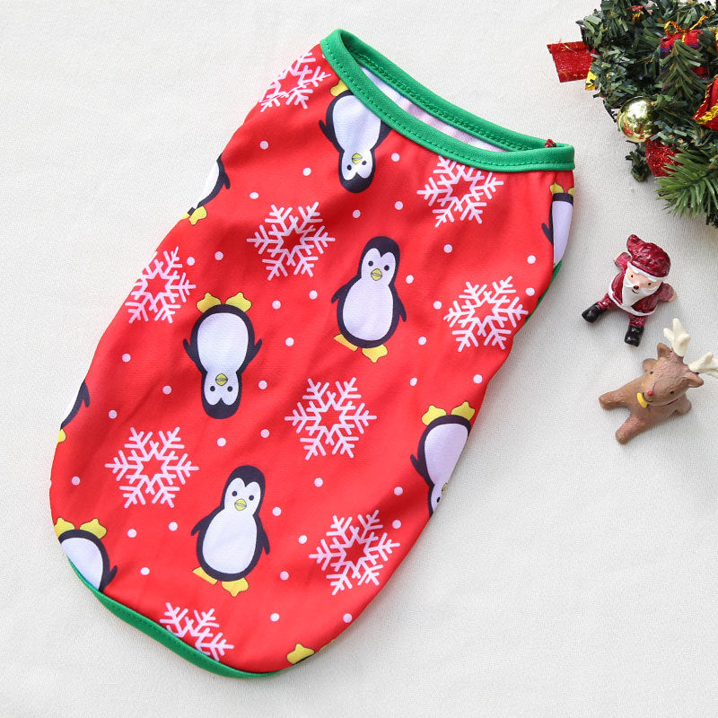 Red baby romper with penguin and snowflake pattern on a white surface with Christmas decorations.