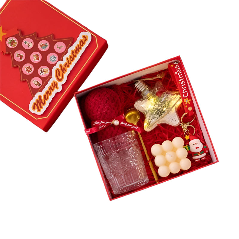 Christmas-themed gift set with a sunflower glass cup, metal spoon, bear towel, Christmas lantern, magic cube candle, and Santa Claus key pendant in a red box.