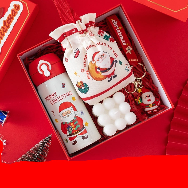 Set of Christmas-themed items including a thermos, candy bag, keychain, and candle in a box.