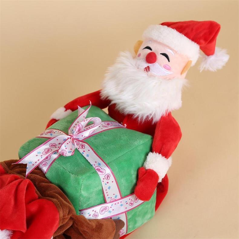 Plush toy resembling Santa Claus holding a green gift box with a pink ribbon on a beige background