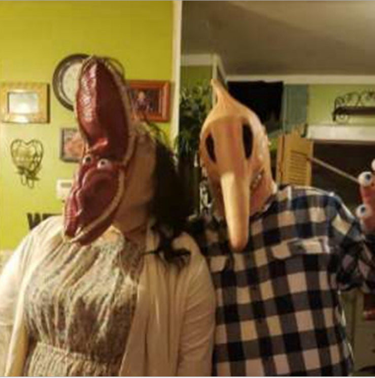Two people wearing large animal head masks in a room with green walls and various decorations.