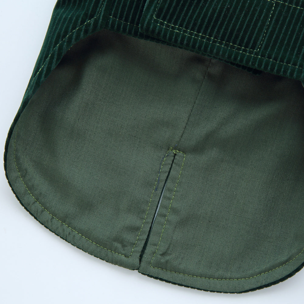 Close-up of a green corduroy jacket pocket on a white background