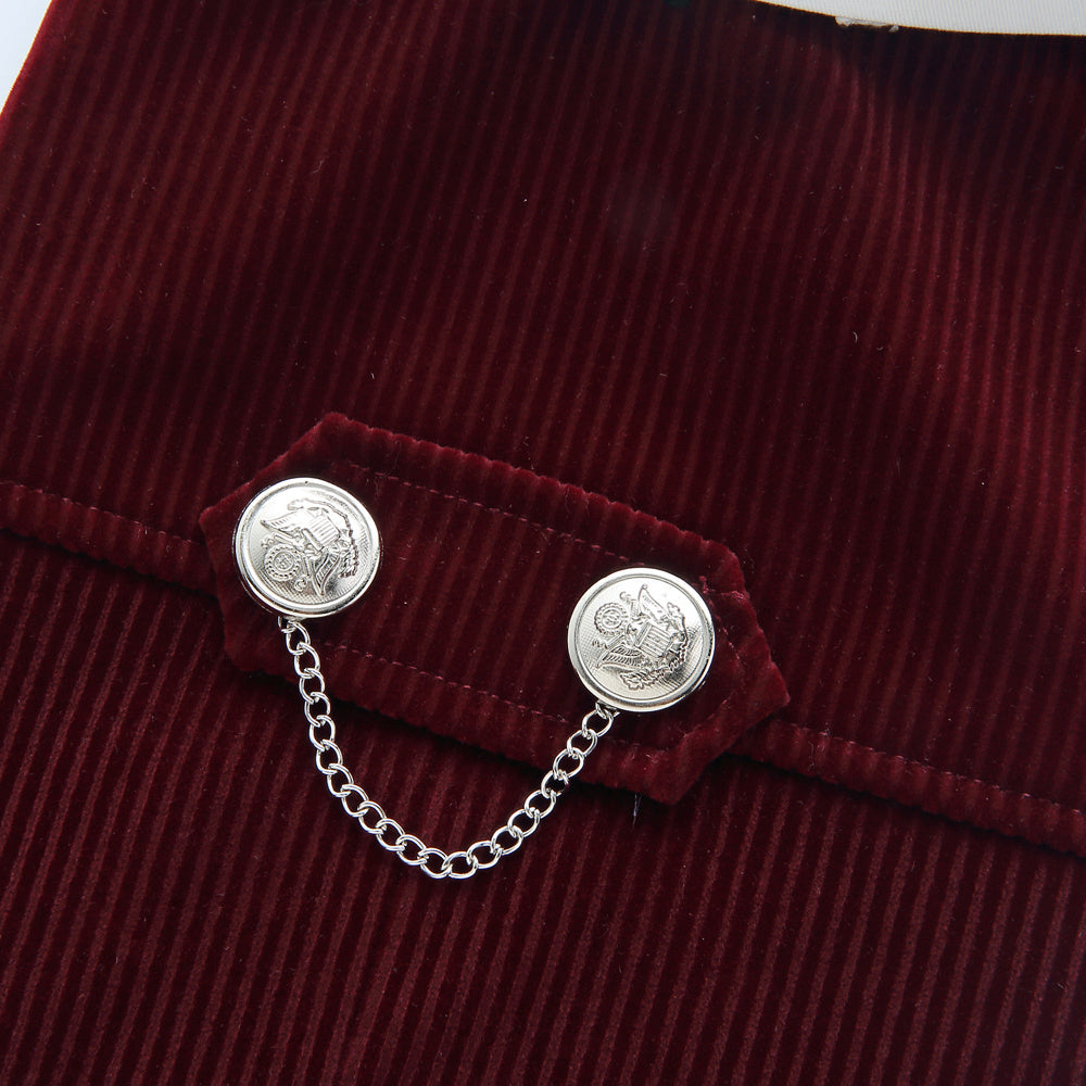 Silver brooch with chain on a burgundy textured fabric background