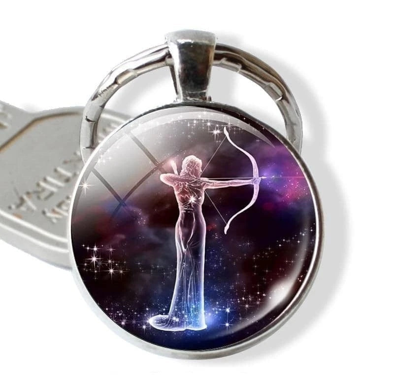 Keychain with a zodiac design of a woman with a bow and arrow against a starry background.