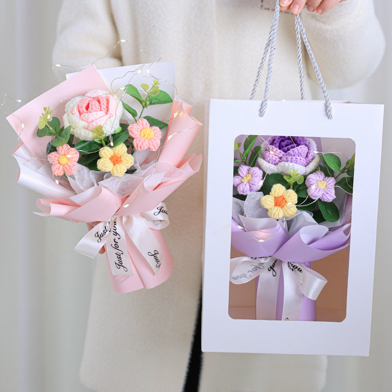 Floral bouquet with pink ribbons and a matching gift bag on a neutral background