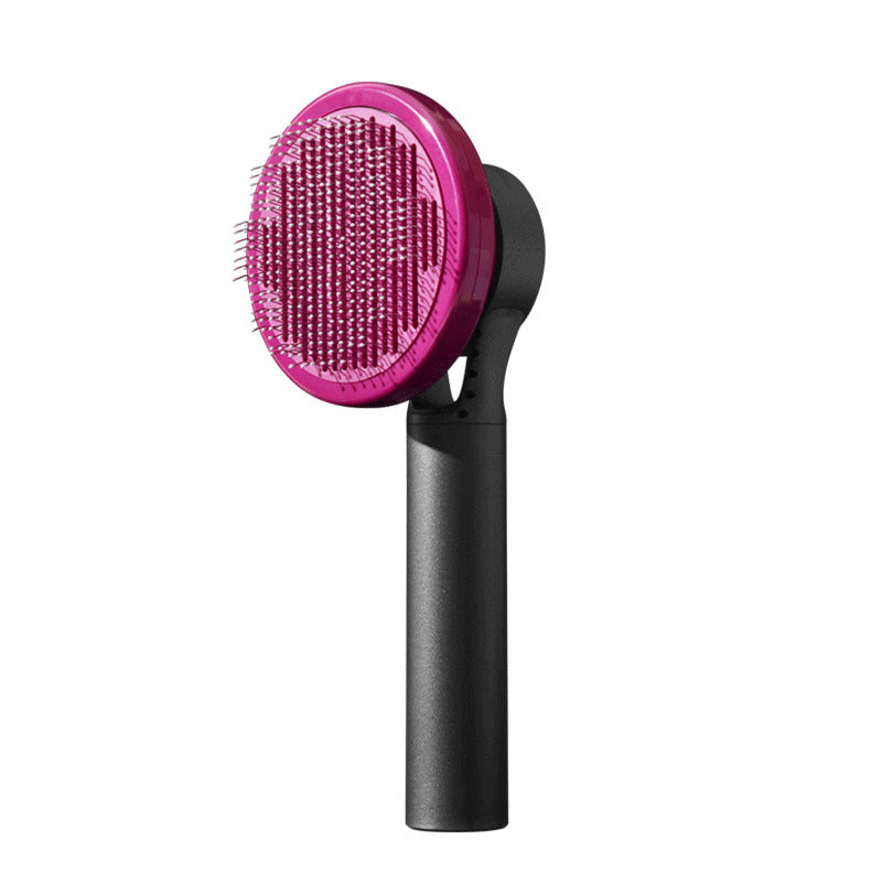 Hairbrush with pink bristle head and black handle on a white background