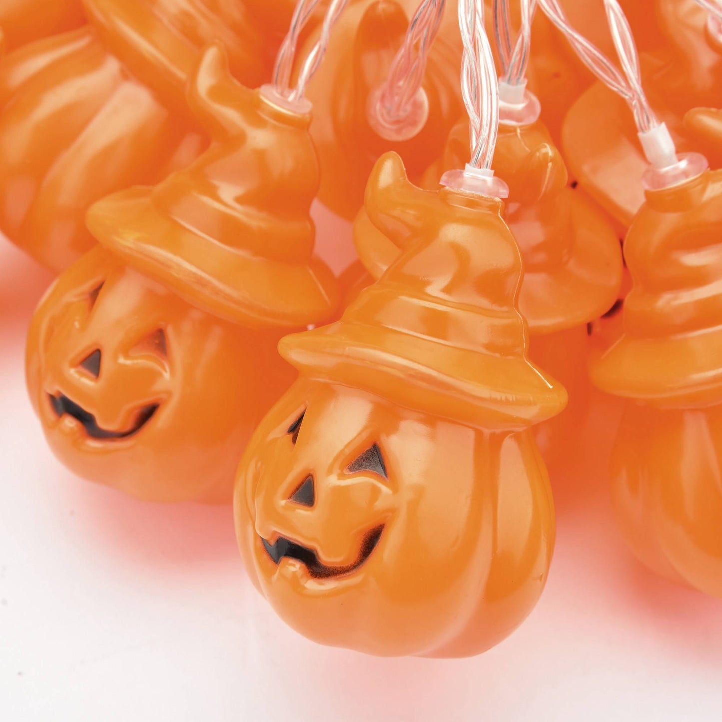 Halloween string lights shaped like jack-o'-lanterns on a white background