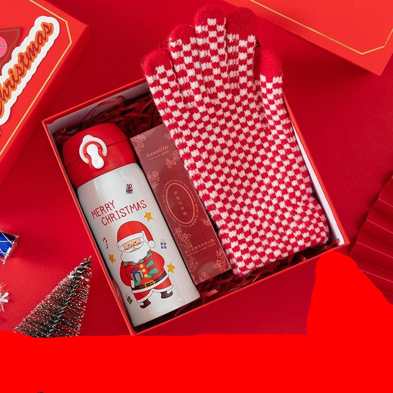Christmas-themed gift set with thermos, hand cream, and gloves on a red background