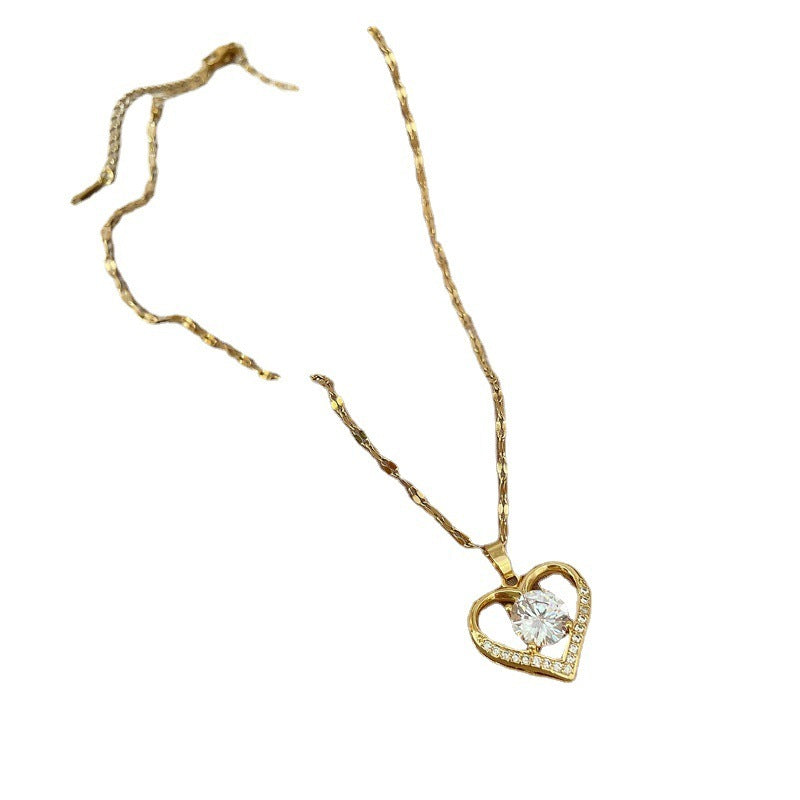 Gold necklace with a heart-shaped pendant on a white background