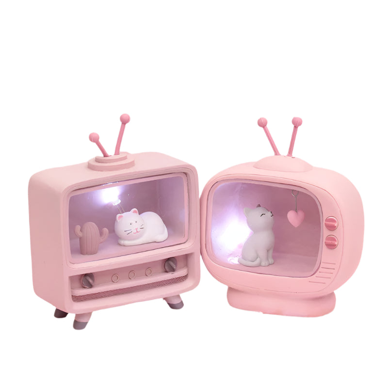 Two small pink vintage-style televisions with cat figurines on a pink and white marbled background.