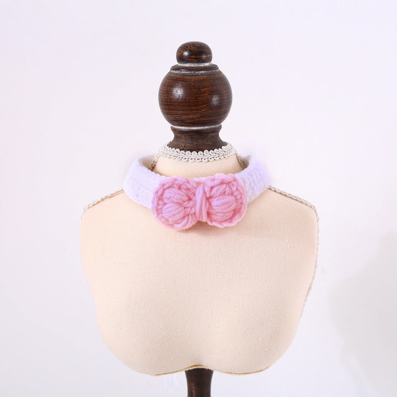 Pink knitted bow with white lace on a mannequin bust against a white background