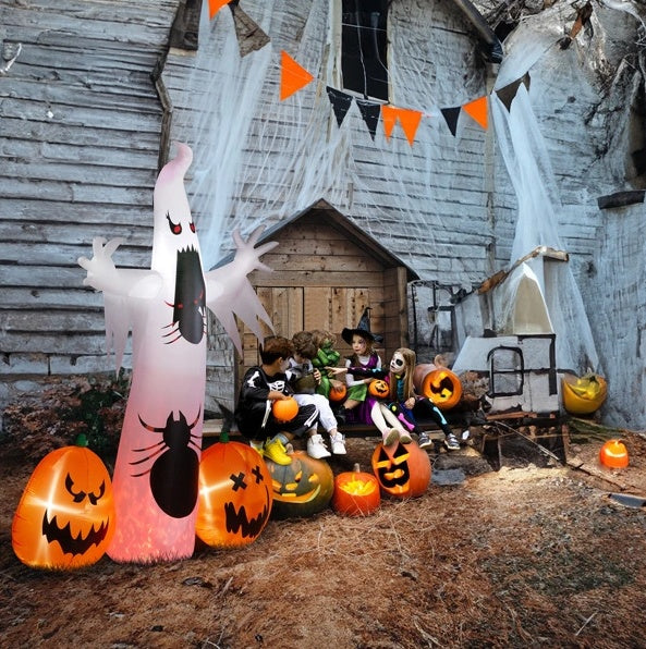 Halloween-themed outdoor scene with inflatable ghost, pumpkins, and decorations in front of a rustic wooden building.