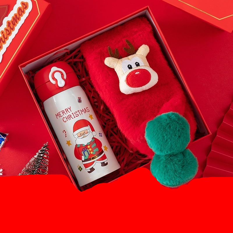 Christmas-themed thermos cup and children's scarf in a red box with festive decorations.