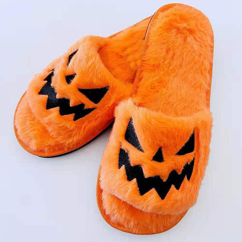Orange slippers with jack-o'-lantern faces on a white background