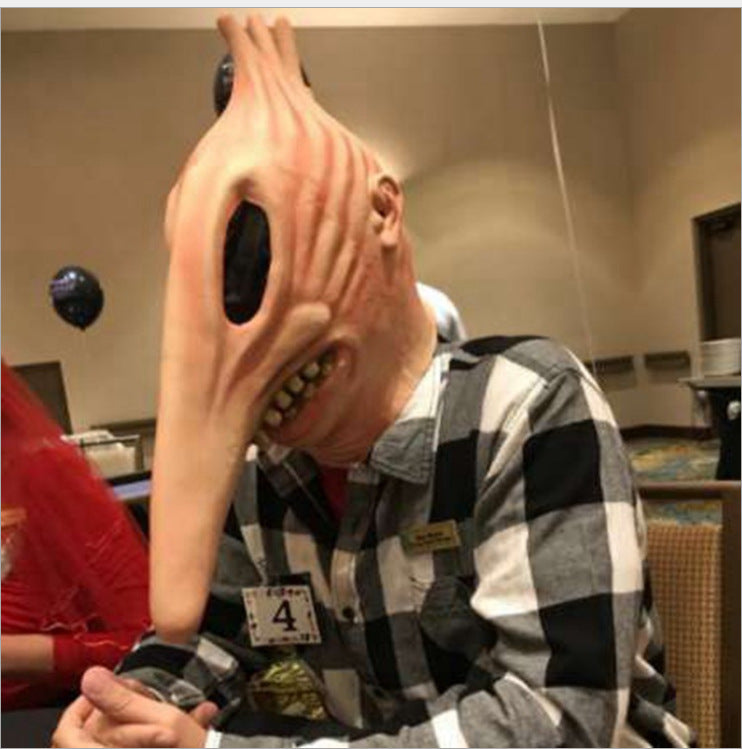 Person wearing a large, textured mask with a checkered shirt in an indoor setting