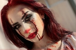 Person with dramatic makeup and red hair, possibly for a Halloween or horror-themed event.
