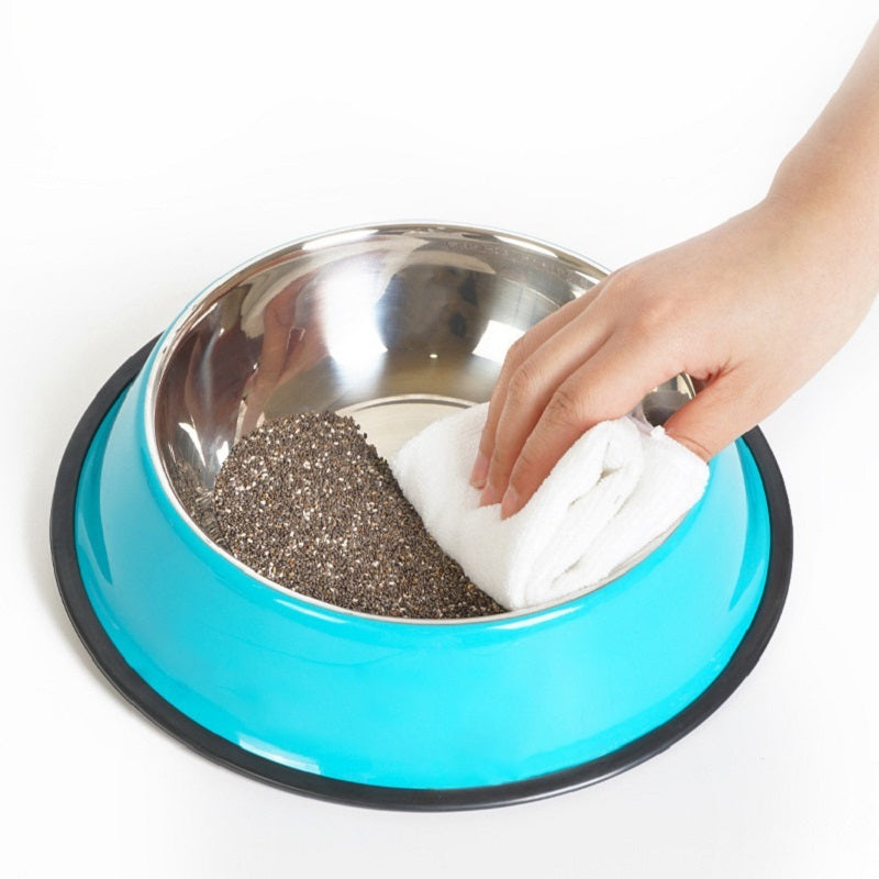 Person cleaning a metal pet bowl with a blue exterior on a white background