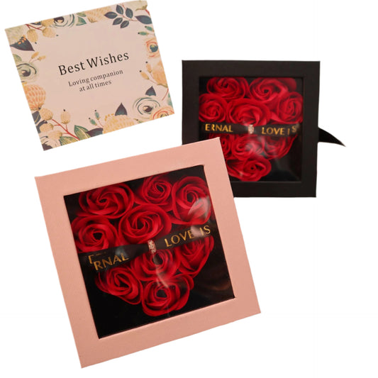 Two boxes of red roses with 'LOVE IS' text on a decorative surface with ribbons and cards.