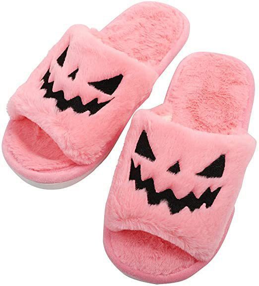 Pink slippers with Halloween pumpkin design on a white background