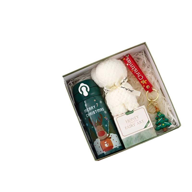 Christmas-themed gift set with thermos, towel, keychain, and tea on a white background