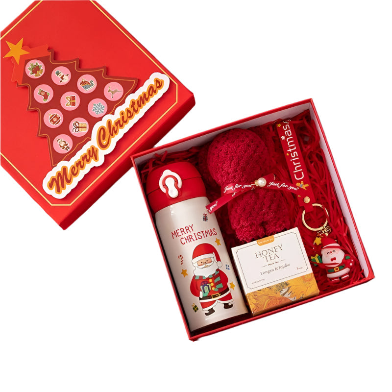 Christmas-themed gift set with thermos, towel, tea, and keychain on a red background