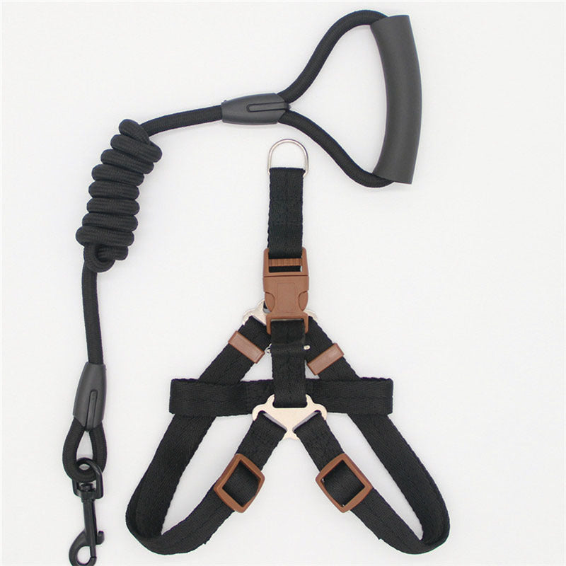 Black dog harness with brown buckles and a leash on a white background