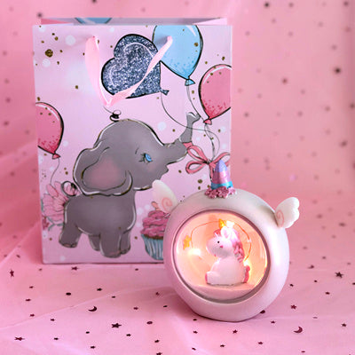 Cute elephant design gift box with a decorative lamp on a pink background