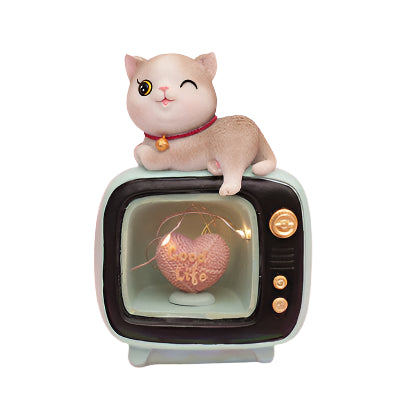 Small figurine of a cat sitting on a vintage TV with a heart message, on a soft pink background.