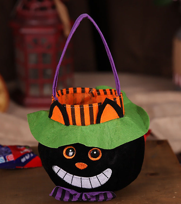 Halloween-themed candy bucket with a green hat and purple handle on a wooden surface.