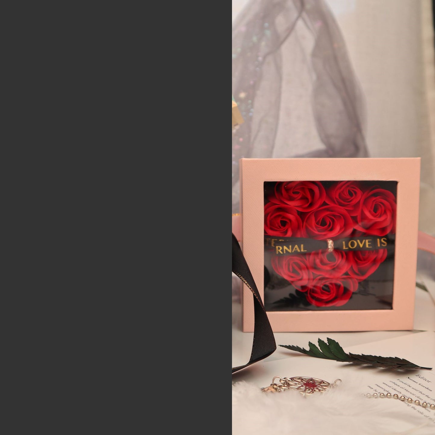 Heart-shaped box with red roses and 'Eternal Love is' text on a surface.