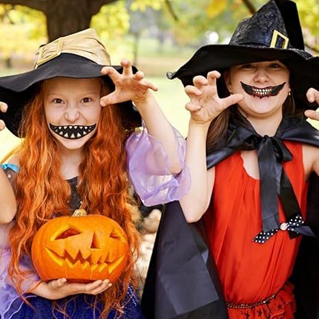Two children in Halloween costumes, one with a witch hat and pumpkin, the other with a black hat and cape, posing outdoors.
