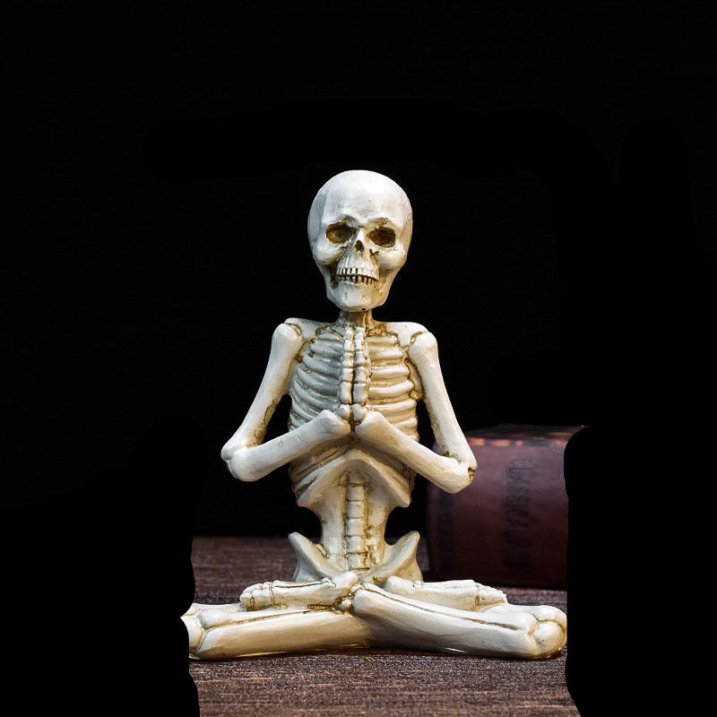Skeletal figurine in a meditative pose with measurements on a dark background
