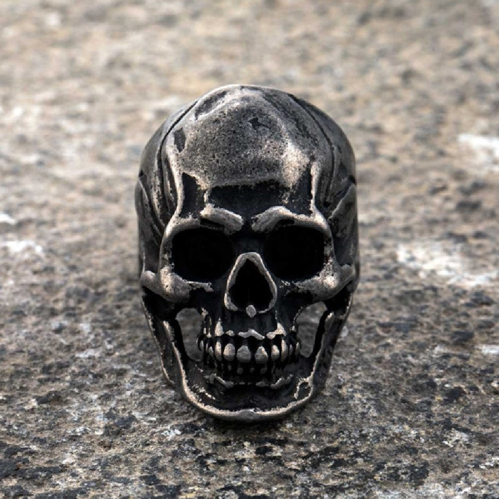 Skull-shaped metal object on a textured surface