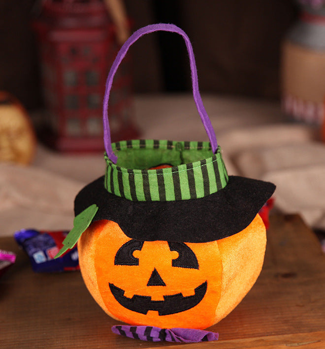 Halloween-themed pumpkin basket with a witch hat on a wooden surface.