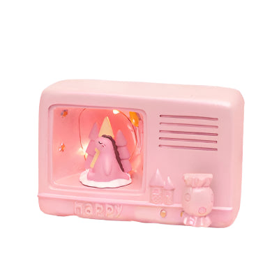 Pink toy radio with a unicorn inside on a soft pink surface