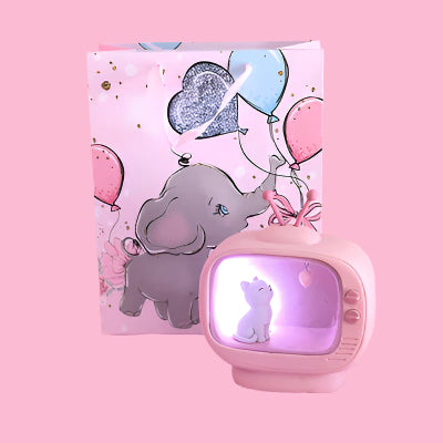 Small vintage-style television with a white dog on screen, next to a card with an elephant and balloons on a pink background.