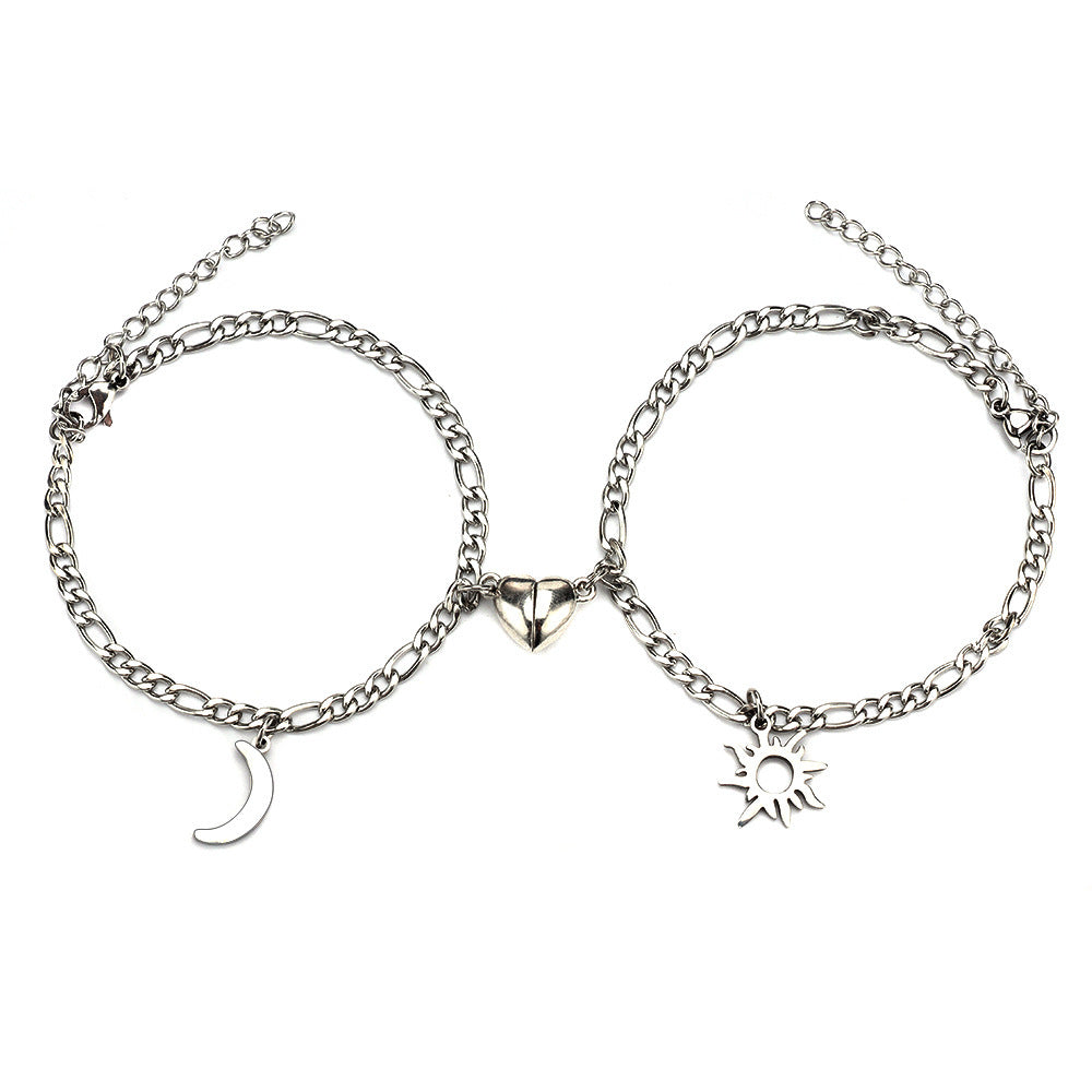 Two silver anklets with moon, heart, and sun charms on a white background
