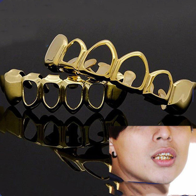 Gold grillz on a reflective surface with a person wearing them.