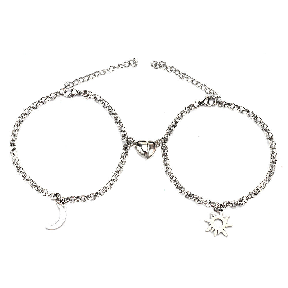 Two silver anklets with moon, triangle, and sun charms on a white background