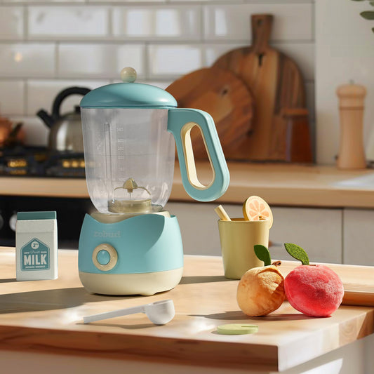 Blue baby blender on a kitchen counter with fruits and a cup in the background